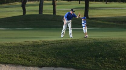 A man and a child on a golf course.