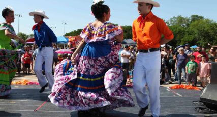 A crowd of people watching a mexican dance.