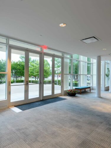 The lobby of a large office building with large windows.