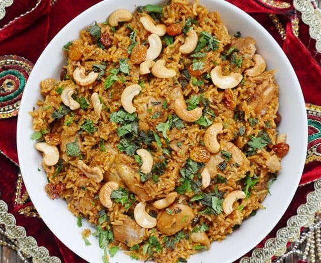 A bowl of rice with nuts and cashews.