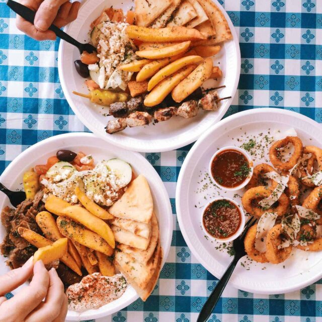 Three plates of food on a table with a checkered tablecloth.