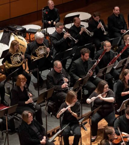 Symphony orchestra in a large auditorium.